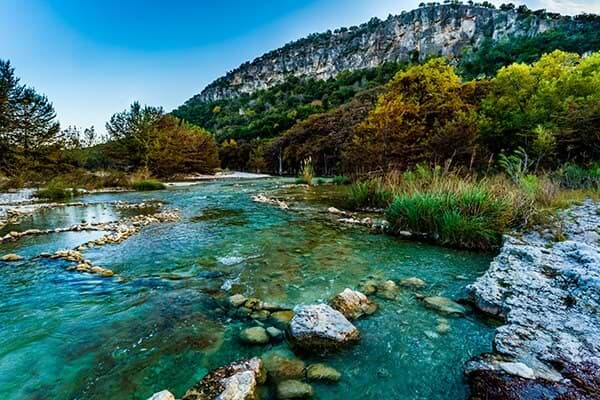 texas camping mountain range view of forest with vibrant blue river running through the center