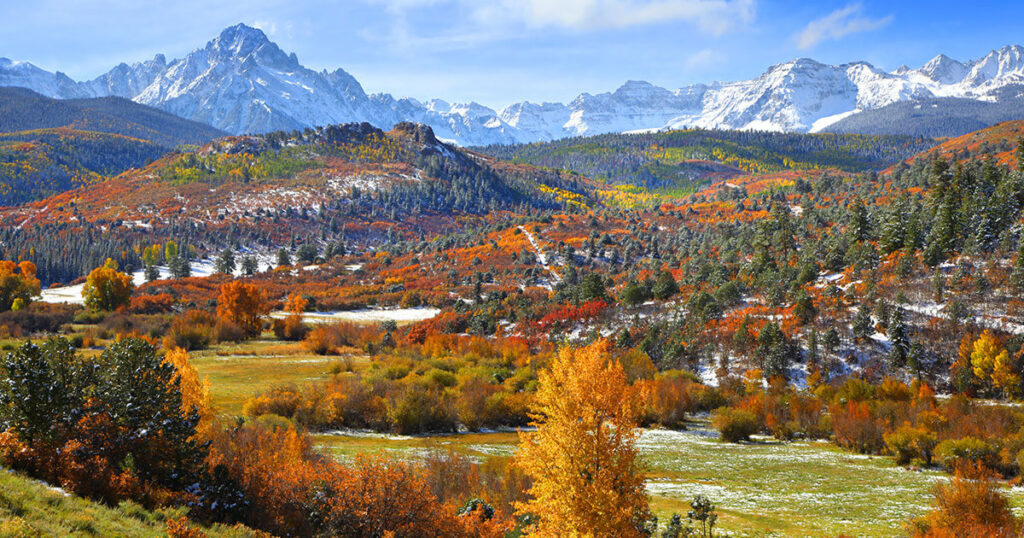 Ridgway State Park campground with San Juan Mountains and reservoir in the background.