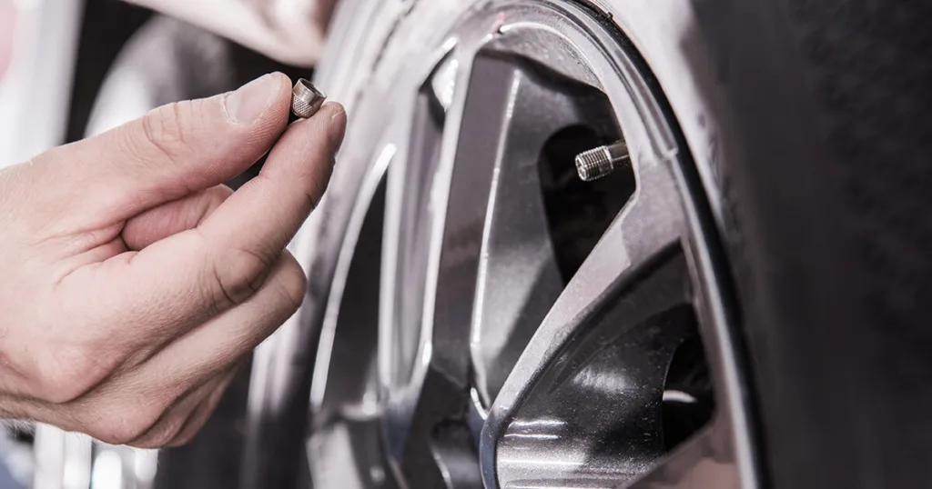 A person checking and maintaining the tires of their travel trailer. Proper tire maintenance, including regular inspection, rotation, and replacement when necessary, is vital for safe and smooth travels, preventing blowouts and improving fuel efficiency.