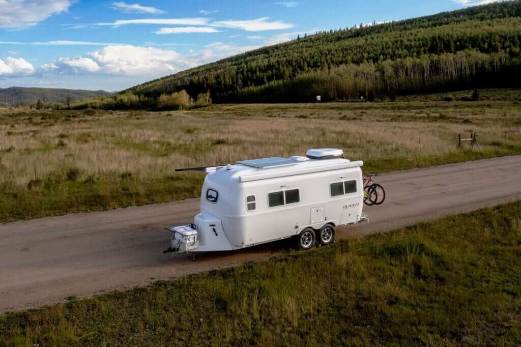 An off-grid camping scene featuring the Legacy Elite 2 travel trailer.