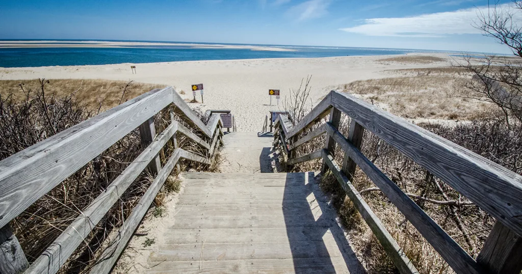 View of Cape Cod National Seashore, showcasing pristine sandy beaches, rolling dunes, and sparkling blue waters.