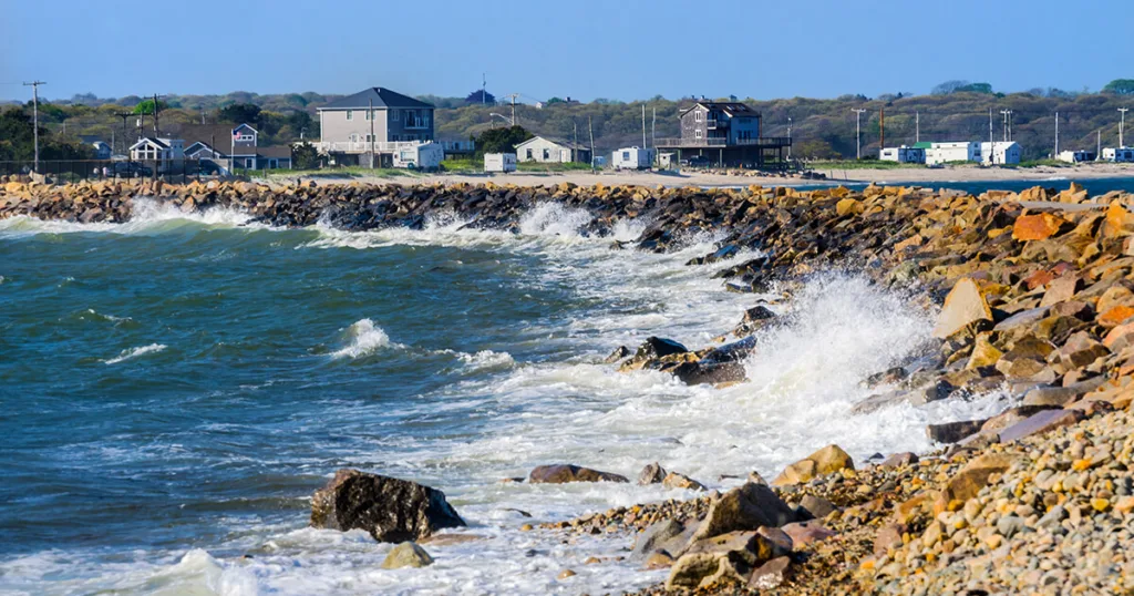 Horseneck Beach State Reservation, showcasing a long stretch of pristine shoreline, gentle waves, and sunbathers enjoying the coastal beauty and relaxing atmosphere.