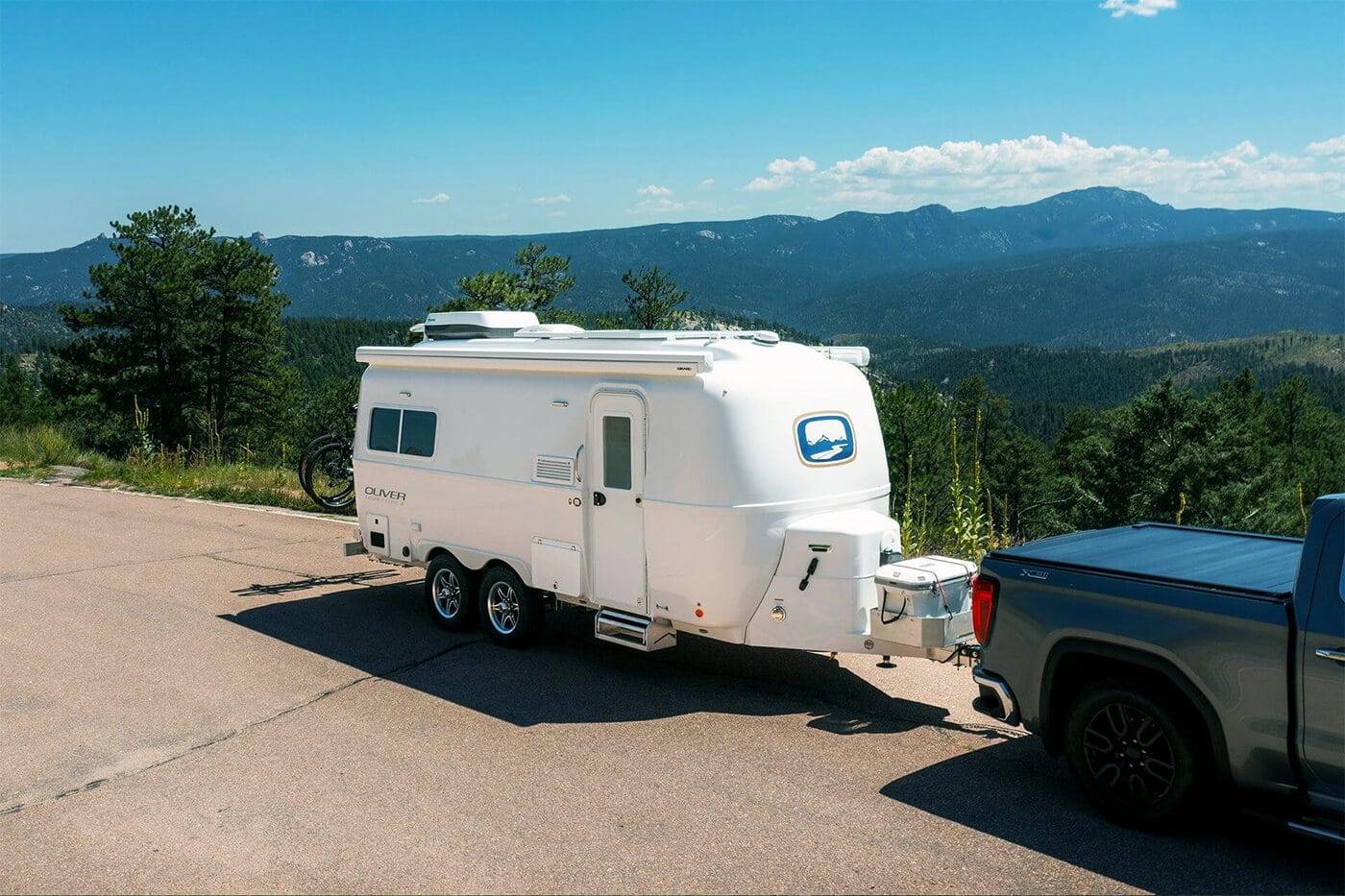 A camper and travel trailer rv parked by a stunning mountain range, with a sense of wanderlust and freedom in the air.