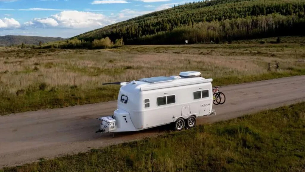 An off-grid camping scene featuring the Legacy Elite 2 travel trailer.