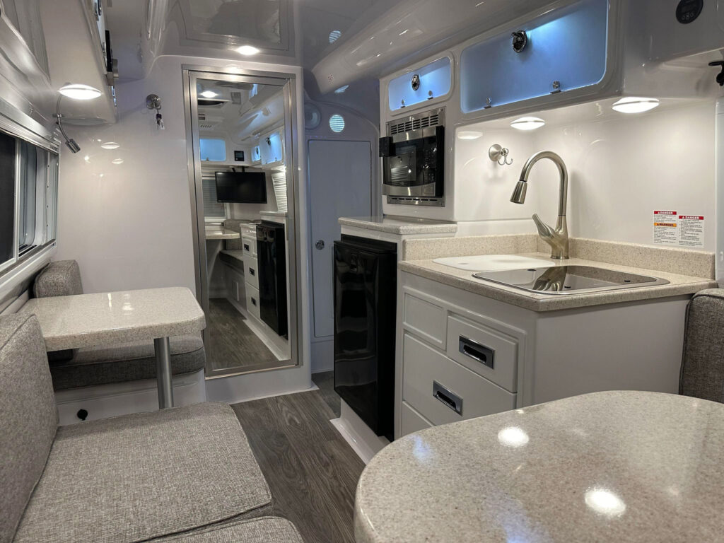 The 2024 Oliver Legacy Elite showcases handcrafted dovetail kitchen drawers and cabinet doors, along with decorative day and night shades that provide added privacy and help keep the interior cool when needed.