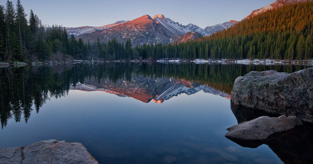 The majestic Longs Peak is mirrored in the tranquil waters of Bear Lake in Rocky Mountain National Park