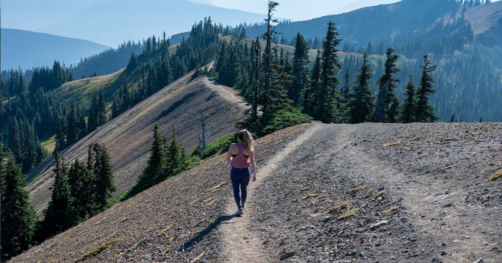 Young woman hiking on Hurricane Ridge trail in Olympic National Park, Washington on sunny autumn afternoon