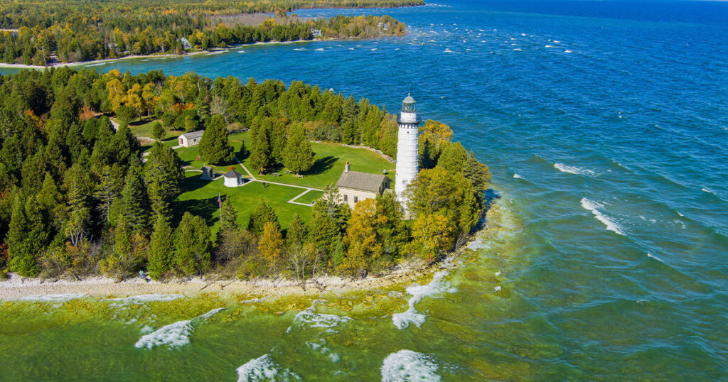 Door County, Wisconsin: A scenic coastal landscape with cherry trees in bloom and a lighthouse standing tall against Lake Michigan.