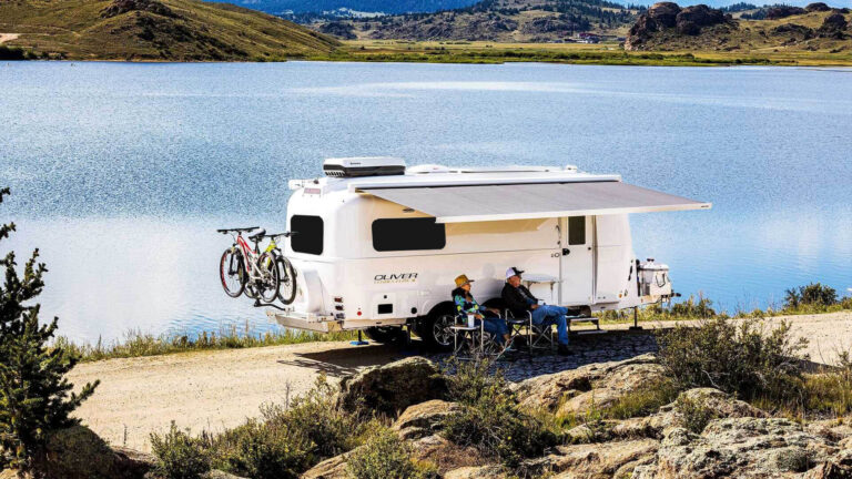 A couple relaxing with their travel trailer