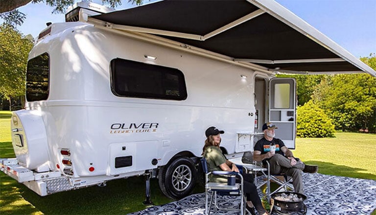 travel trailer towed by a mid-size SUV beside a large motorhome RV, highlighting size and towing differences.