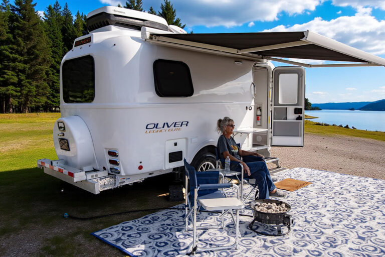 Legacy Elite small camper with a powered awning extended for outdoor use.