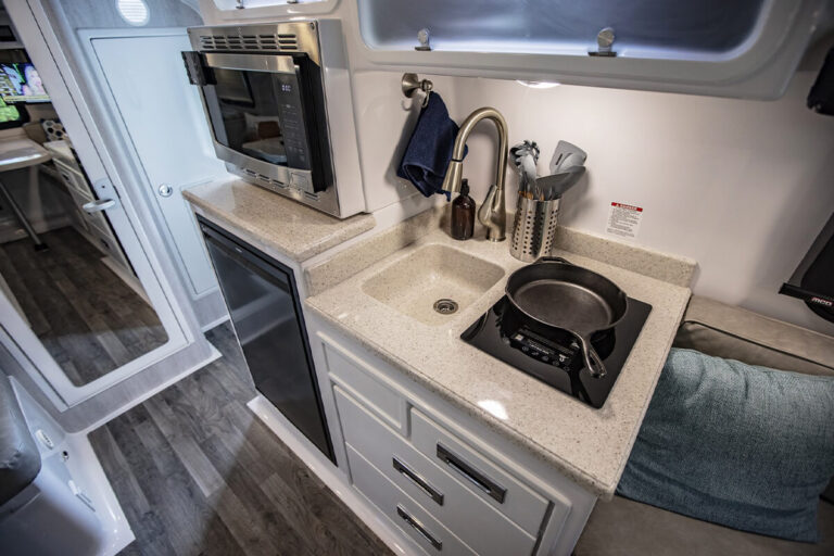 Interior view of the Legacy Elite small camper kitchen featuring a stove and sink.