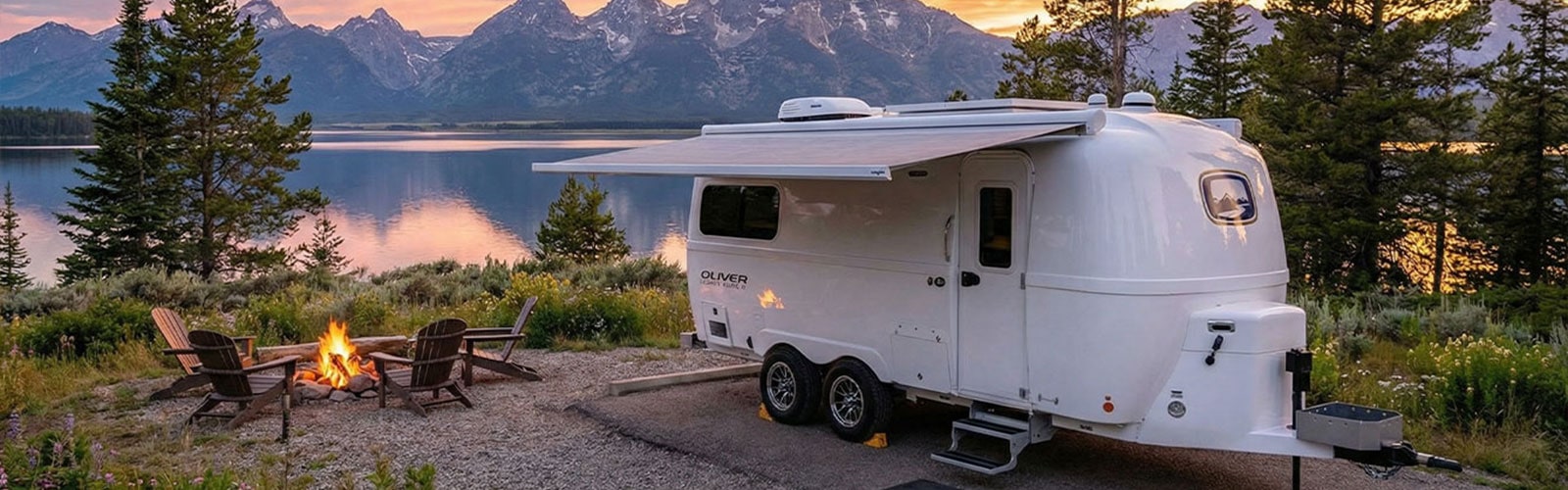 Side-by-side comparison of Oliver Legacy Elite II and Airstream Flying Cloud 23CB travel trailers parked in a scenic campground, showcasing fiberglass vs aluminum exteriors.